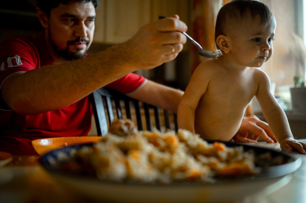 dad-feeds-his-son-the-family-is-having-dinner-at-2024-12-06-12-32-20-utc